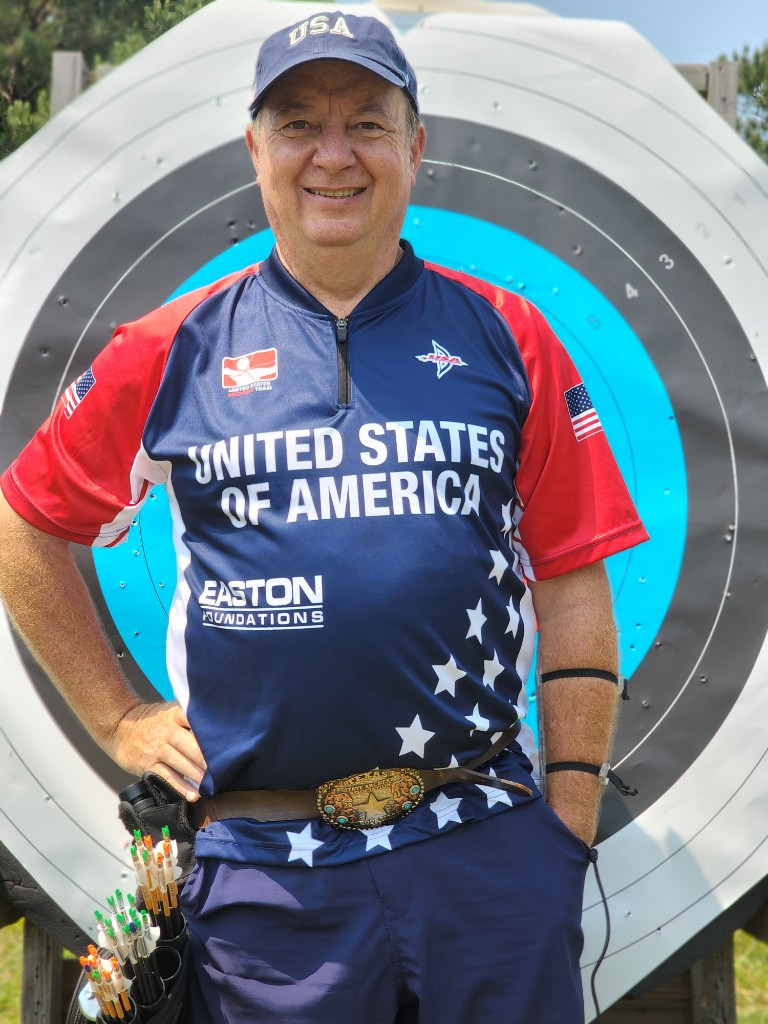 Dave Nesbitt in USA Archery team uniform at an outdoor range